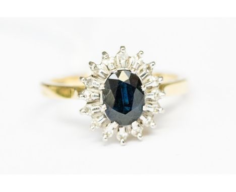 A sapphire and diamond 18ct gold cluster ring, the central oval sapphire with a diamond set border, size O1/2, total gross we