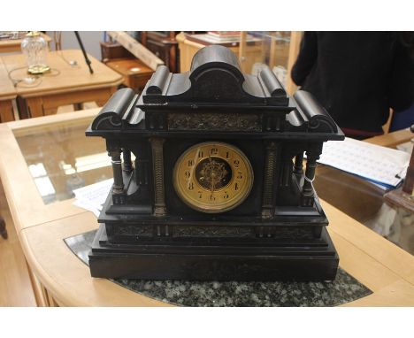 A Victorian slate mantle clock, architectural design with pillared columns and carved decoration, brass decorated dial,