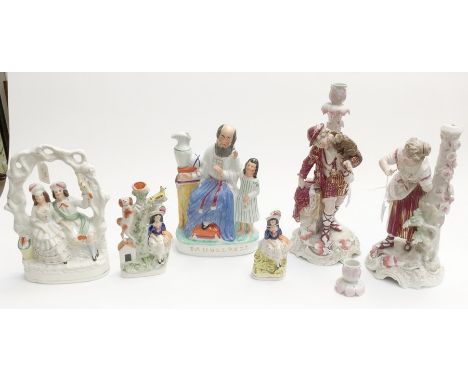 A pair of late 19th Century figurines, candlestick holders together with four Victorian Staffordshire figure groups, comprisi