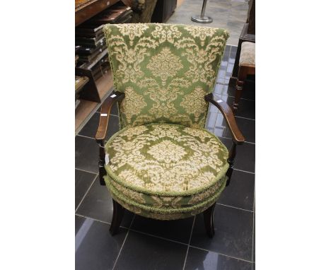A Victorian mahogany upholstered chair, tapestry upholstery circular seat, raised on sabre feet.