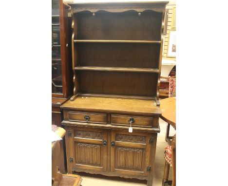A 20th Century oak dresser, moulded cornice above egg trim finials with two shelves, rectangular base fitted with two single 