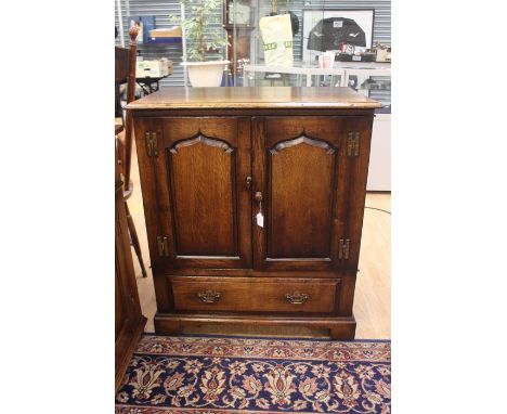 A 20th Century oak Titchmarsh &amp; Goodwin Television cabinet, rectangular top above two panel doors on a single drawers.