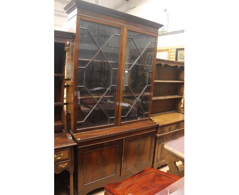 A George III mahogany glazed bookcase, circa 1820, dentil pediment above two glazed doors opening to four shelf bookcase, on 