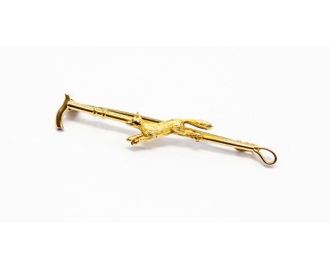 A 9ct gold hunting brooch in the form of a riding crop, depicting a fox in motion, length approx. 50mm, total gross weight ap