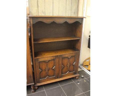 A 20th Century oak open bookcase, rectangular top above two tier shelving on two panel cupboard opening to two tier shelves, 