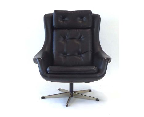 A 1970's black button upholstered tub armchair on a five-star swivel base