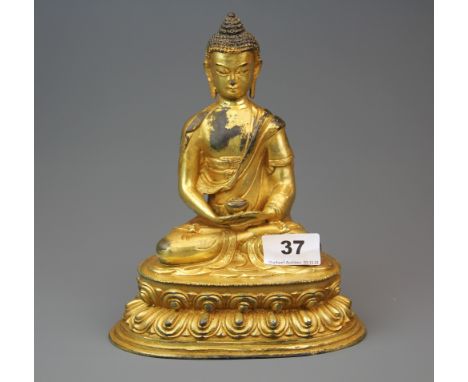A Tibetan gilt bronze figure of a seated Buddha, H. 31cm.