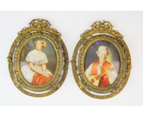 A pair of gilt framed hand painted portrait miniatures of a young woman and a musician one signed Magnus, L. 14cm.
