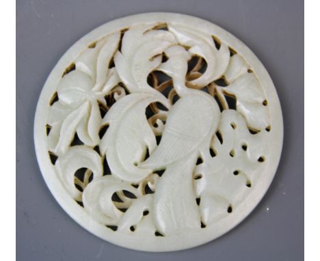 A lovely Chinese carved mutton fat jade circular box insert decorated with a bird among foliage, dia. 9.5cm.