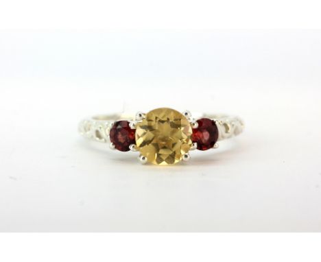 A 925 silver ring set with round cut citrine flanked by garnets, (P.5).