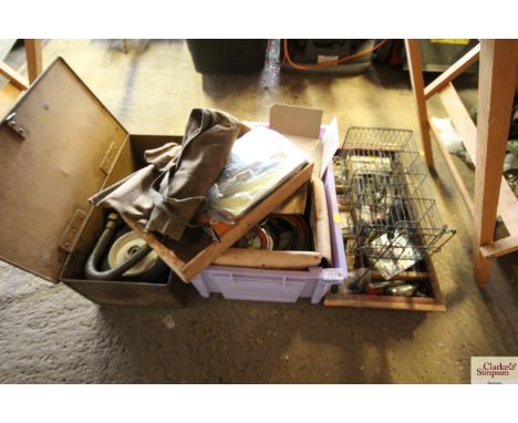 A metal trunk containing padlocks; hard rubber wheels; a plastic box with canvas pouch of hand tools; spark plugs; various wi