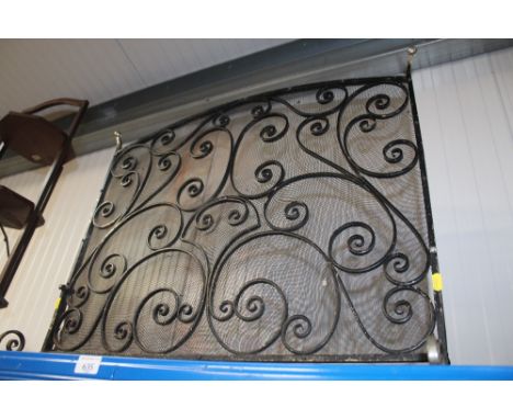 A wrought iron fire screen