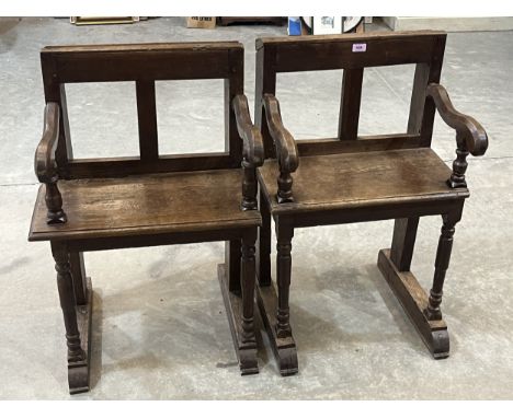 A near pair of French 17th century joined oak church armchairs on turned forelegs and sledge feet
