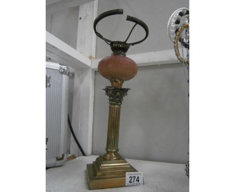 A Victorian brass Corinthian column oil lamp base with pink glass font, gallery a/f and no shade or chimney