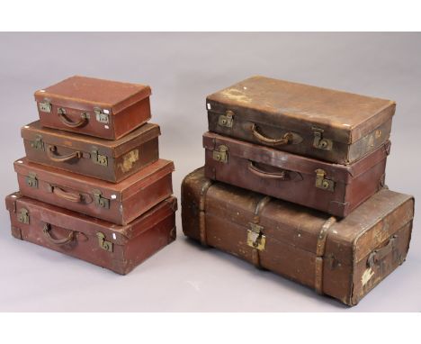 A vintage fibre-covered travelling trunk with a hinged lift-lid, 33” wide; &amp; six various vintage suitcases. 