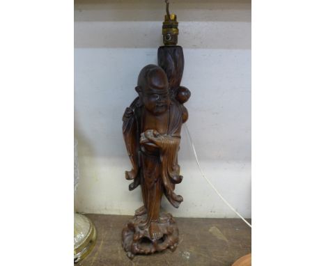 A Chinese carved wood figural Buddha table lamp