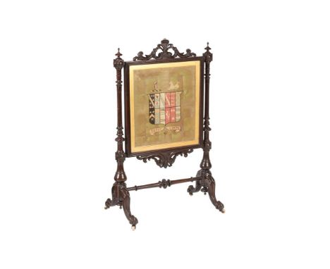 A VICTORIAN STAINED OAK FIRESCREEN SECOND HALF 19TH CENTURYThe cross-stitched armorial panel with motto SOYEZ FERME (Be Firm)