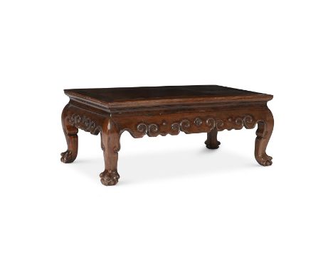 A CHINESE HARDWOOD KANG TABLELATE QING DYNASTY The top panel within a rectangular frame, above a shaped apron with scroll on 