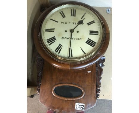 A mahogany wall clock the circular dial with Roman numerals W+F Terry Manchester with visible pendulum.