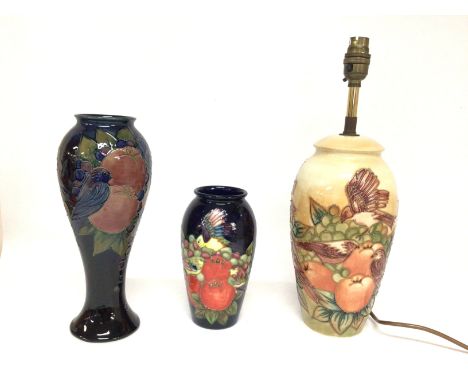 A collection of Moorcroft with designs of fruit and birds including vases and a lamp, ranging from 18 to 38cm tall. No obviou