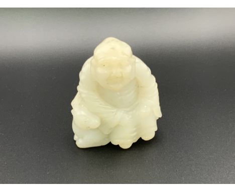 A small carved jade figure of a Chinese deity seated upon a goat. 6cm.