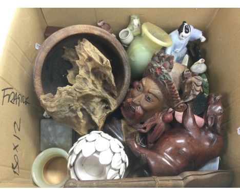 A box containing various Oriental items including wood carvings, ceramic figures etc.