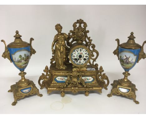 A French late 19th century gilt metal clock with porcelain panels and surmounted with a female classical figure sold with two