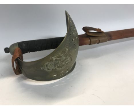 A cavalry sword with engraved blade and leather scabbard