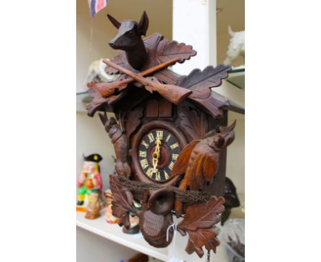 A carved wooden Cuckoo clock with three weights 