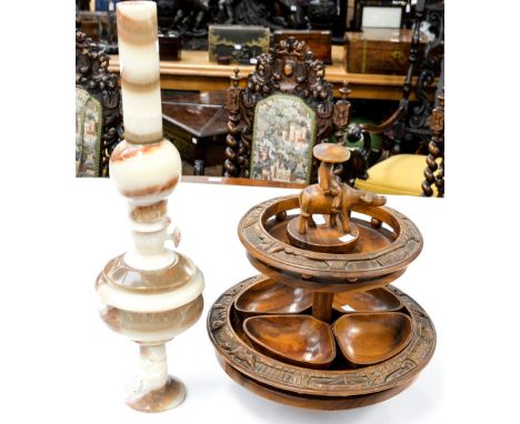 A 20th Century hardwood revolving pedestal two tier lazy Susan, the top surmounted by a native man on a Buffalo; together wit