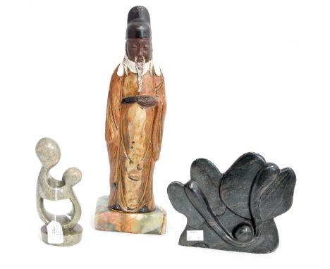 A 20th Century ceramic figure of a Japanese elder mounted on an Onyx plinth; together with two soapstone carvings (3) 