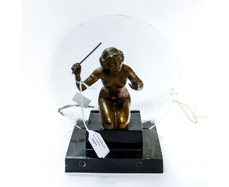 An Art Deco bronzed Spelter table lamp in the form of a nude girl, kneeling, holding aloft a stick, the stepped square base f