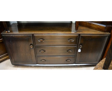 An Ercol Windsor range elm sideboard, fitted with two doors, with three drawers to centre