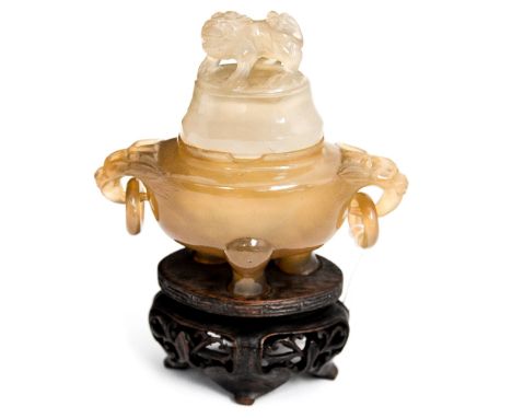 A Chinese amber jade or agate censer on hardwood stand, ring handles, the lid with a Shi finial, 13cm high including stand