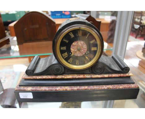 A Victorian black slate and red marble mantle clock, having an eight day movement, scrolled case