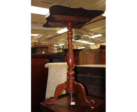 An antique mahogany tripod table with serpentine top 