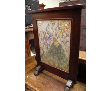 A 19th Century mahogany firescreen, having a later woolwork panel