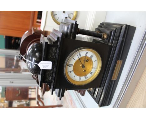 A black granite mantle clock, with four columns, having enamelled dial, with Roman numerals (pendulum but no key) 