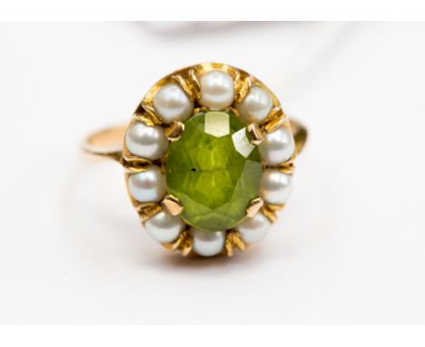 A 9ct peridot and pearl cluster ring, claw set oval cut peridot with surround of ten cultured pearls, stamped 9ct, ring size 