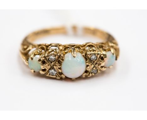 A Victorian 9ct three stone opal and diamond ring, three graduated round opal cabochons with intersecting diamond points, rin