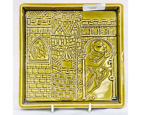 A Poole pottery studio square dish, green glazed, depicting figures in a Medieval Castle, designed by Robert Jefferson 