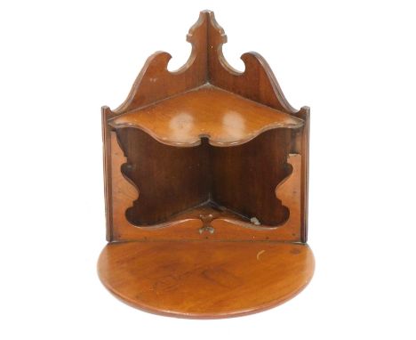 An early 20thC mahogany hanging corner shelf, with semi circular top, above shaped under section, with carved sides on a moul