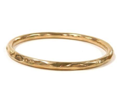 A 9ct rose gold bangle, of faceted form, 8.0g, 8.5cm wide.