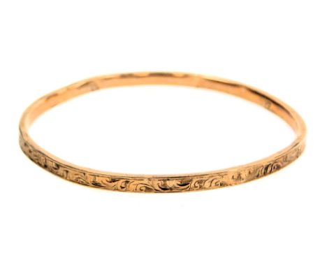 A rose metal bangle, with engraved foliate decoration, stamped 9ct, 4.5g.