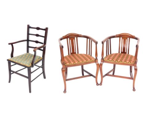 A pair of Edwardian mahogany tub armchairs, upholstered in overstuffed repeating heart shaped pattern fabric, raised on slend