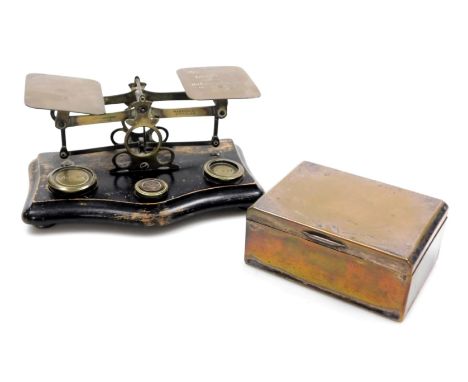 A set of Victorian brass postal scales, on an ebonised base, with weights, 20cm wide. together with a State Express Cigarette