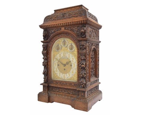 English oak triple fusee musical boardroom clock, the 8" gilded brass arched dial signed Arnold &amp; Lewis, Manchester on an