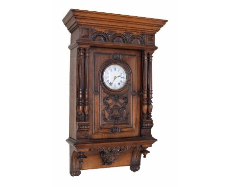 Mahogany veneered two train wall clock striking on a gong, the 4.5" white enamel dial within a panelled stepped carved pillar