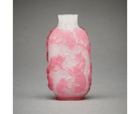 Chinese snuff bottle in white glass with a light red or pink glass overlay depicting monkeys frolicking under a canopy of tre