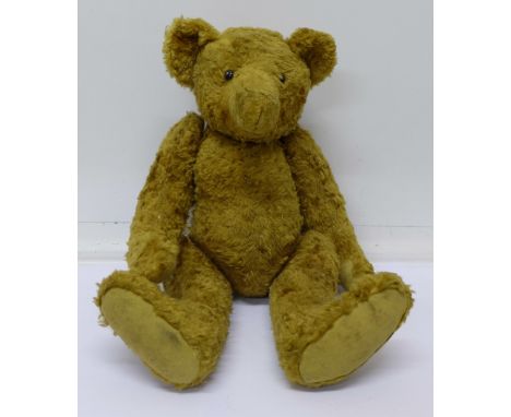 An early 20th Century straw filled Teddy bear with button eyes and hump back, 38cm